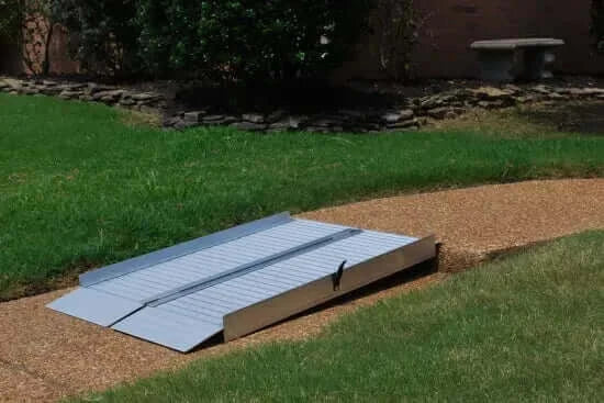 American Access - Sidekick Portable Aluminum Folding Wheelchair Van Ramp - ramp sitting on a walkway unfolded, a side view