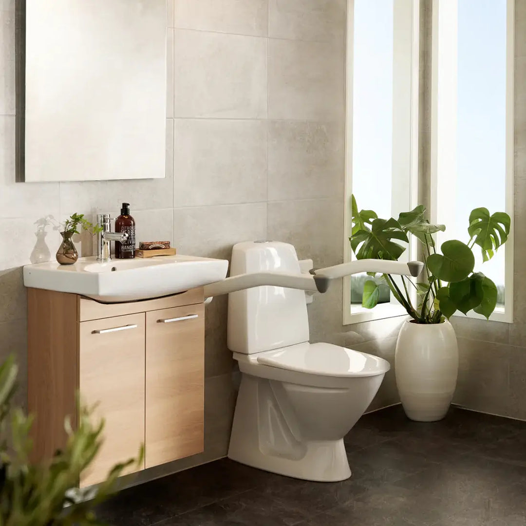Bathroom with a toilet, sink, and window with plants