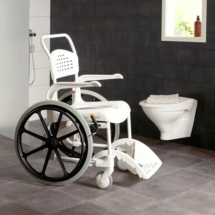 White wheelchair with shower attachment in a bathroom setting