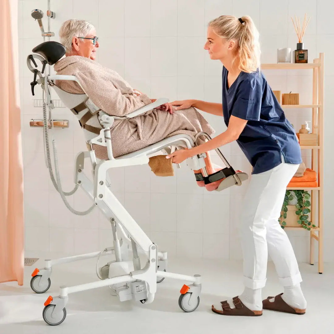 Caregiver assisting an elderly person using a wheelchair lift in a home setting.