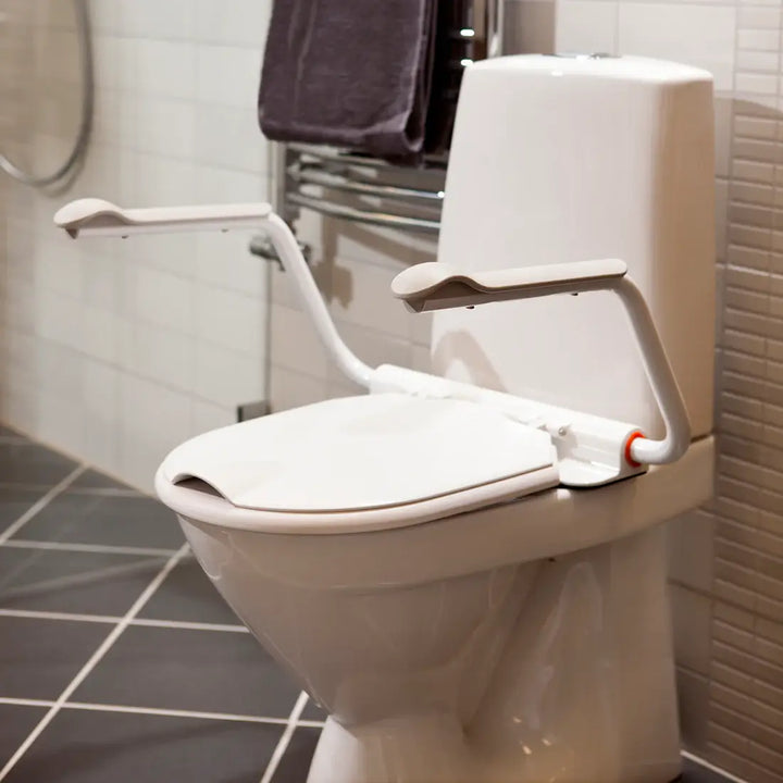 Toilet with a raised seat and grab bars in a bathroom setting