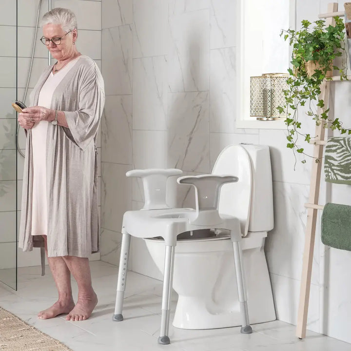 Woman in a bathroom with a toilet seat attachment for elderly or disabled people.