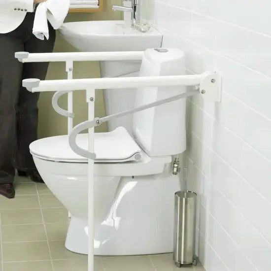 White toilet with a support bar in a bathroom setting