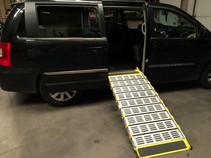 Roll-A-Ramp manual van ramp from Reliable Ramps being shown on a side entrance of a black minivan
