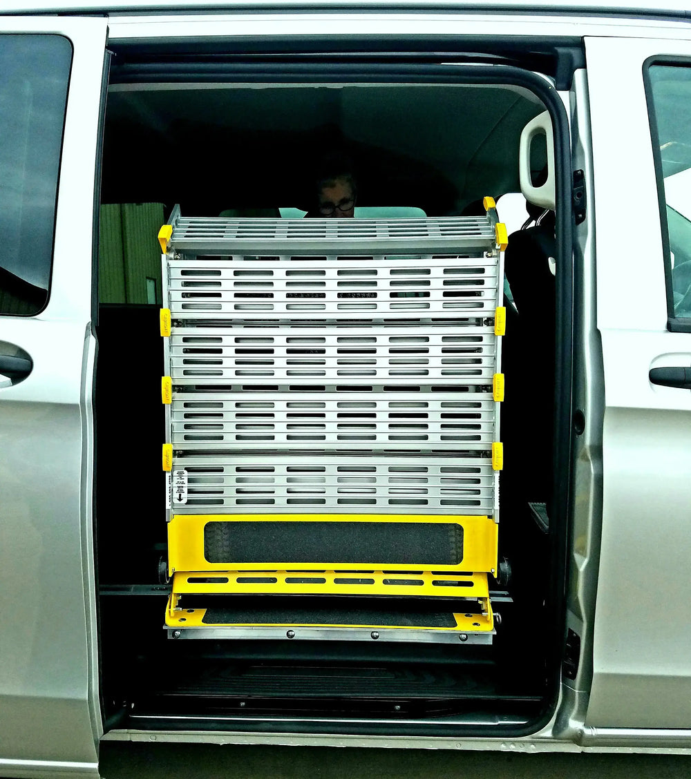 Roll-A-Ramp manual van ramp from Reliable Ramps folded up into a gray van