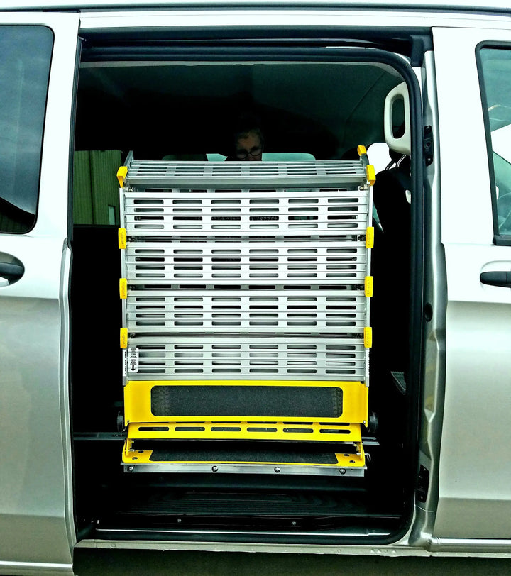 Roll-A-Ramp manual van ramp from Reliable Ramps folded up into a gray van