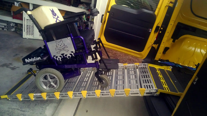 Roll-A-Ramp manual van ramp from Reliable Ramps being used by a purple wheelchair