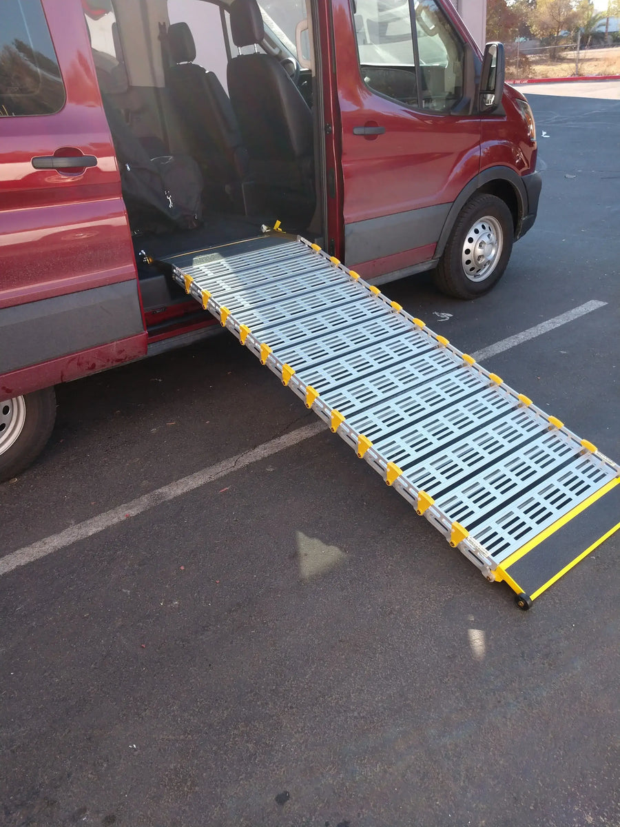 Roll-A-Ramp manual van ramp from Reliable Ramps being used unfolded out the side of a red van