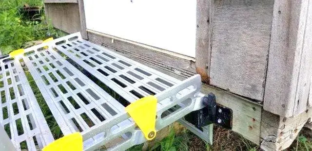Roll-A-Ramp Seg Mount Brackets From Reliable Ramps connected to a shed