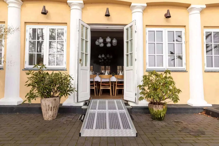 Guldmann - Stepless Wide Folding Pro Portable Wheelchair Ramp setup outside a home