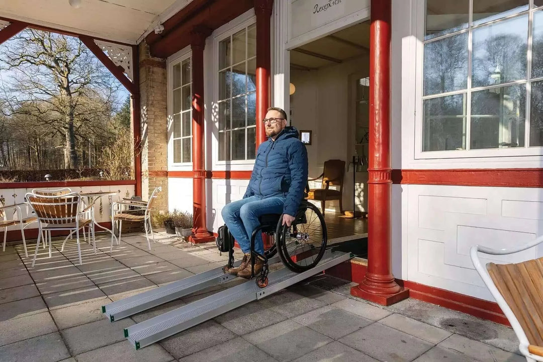 Guldmann - Stepless Telescopic Portable Wheelchair Ramp used by a patient coming out of a house