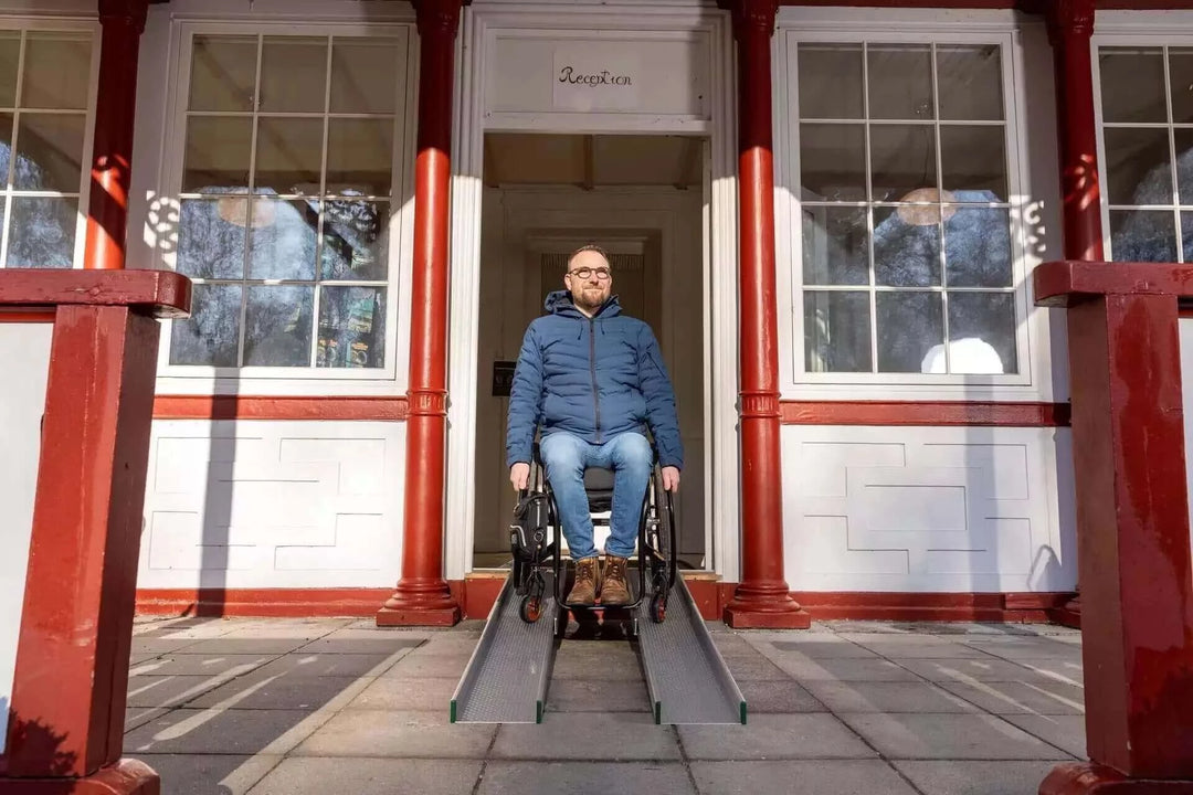 Guldmann - Stepless Telescopic Portable Wheelchair Ramp used by a patient coming out of a house
