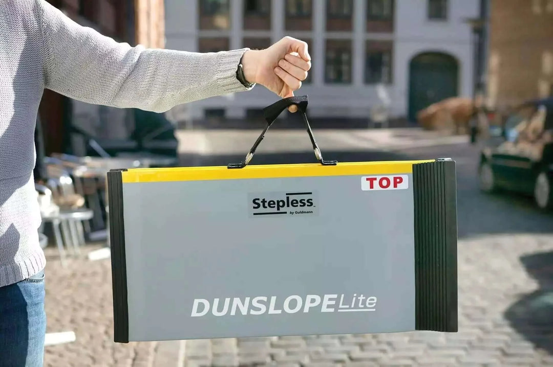 Guldmann - Stepless Single Folding Lite Wheelchair Ramp being held by man folded up showing lightweight features