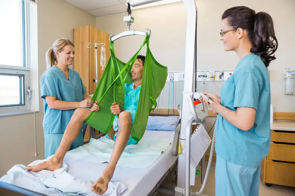 a man in a patient sling being helped by two female nurses