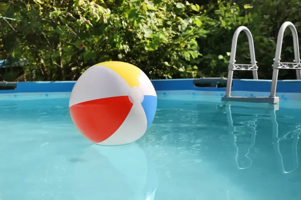 an above ground pool that shows the steps going out of it as well as a beach ball floating in it.