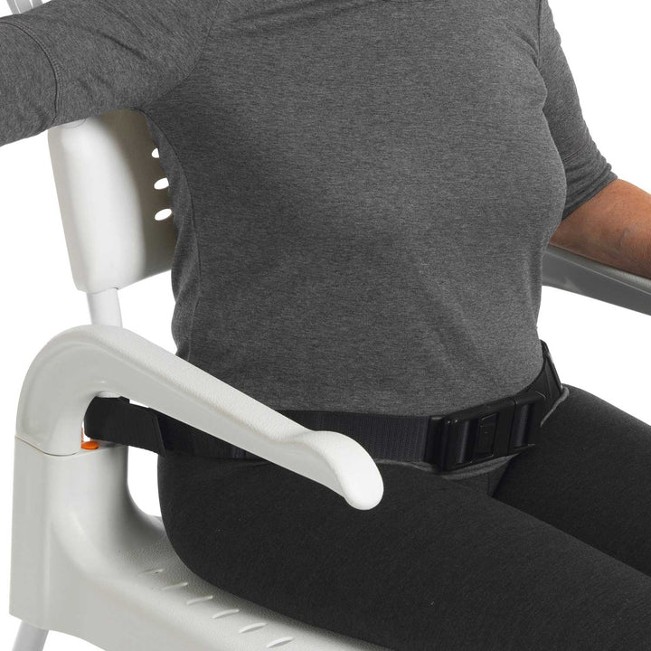 Person sitting in a chair with a belt around their waist, possibly for safety or support.