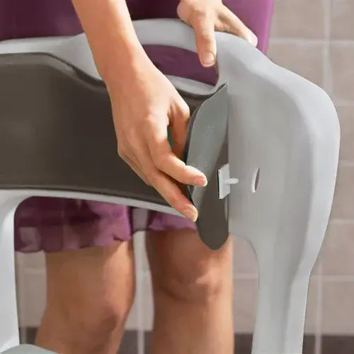 Person using a gray shower stool with a white background