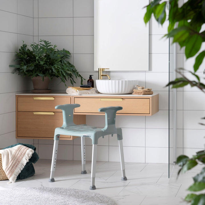 etac swift shower stool/chair from reliable ramps showing green variation in front of the sink