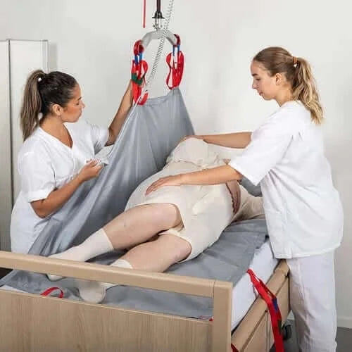 Molift - RgoSling Repositioning Sheet Patient Lifts Accessories Molift with 2 nurses helping a patient in bed