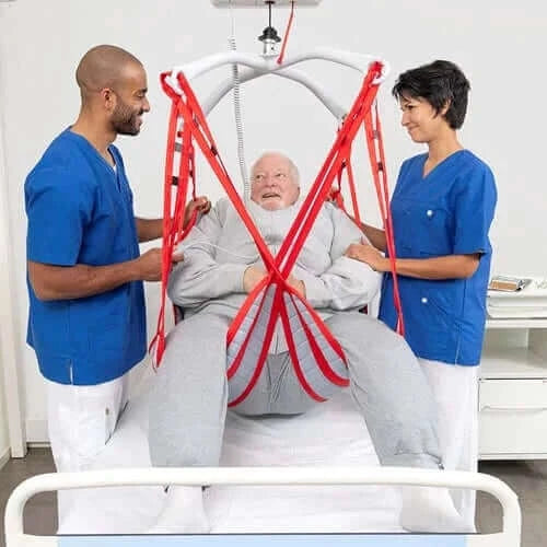 man being helped by two nurses getting out of bed using a patient lift and rgosling mediumback plus sling