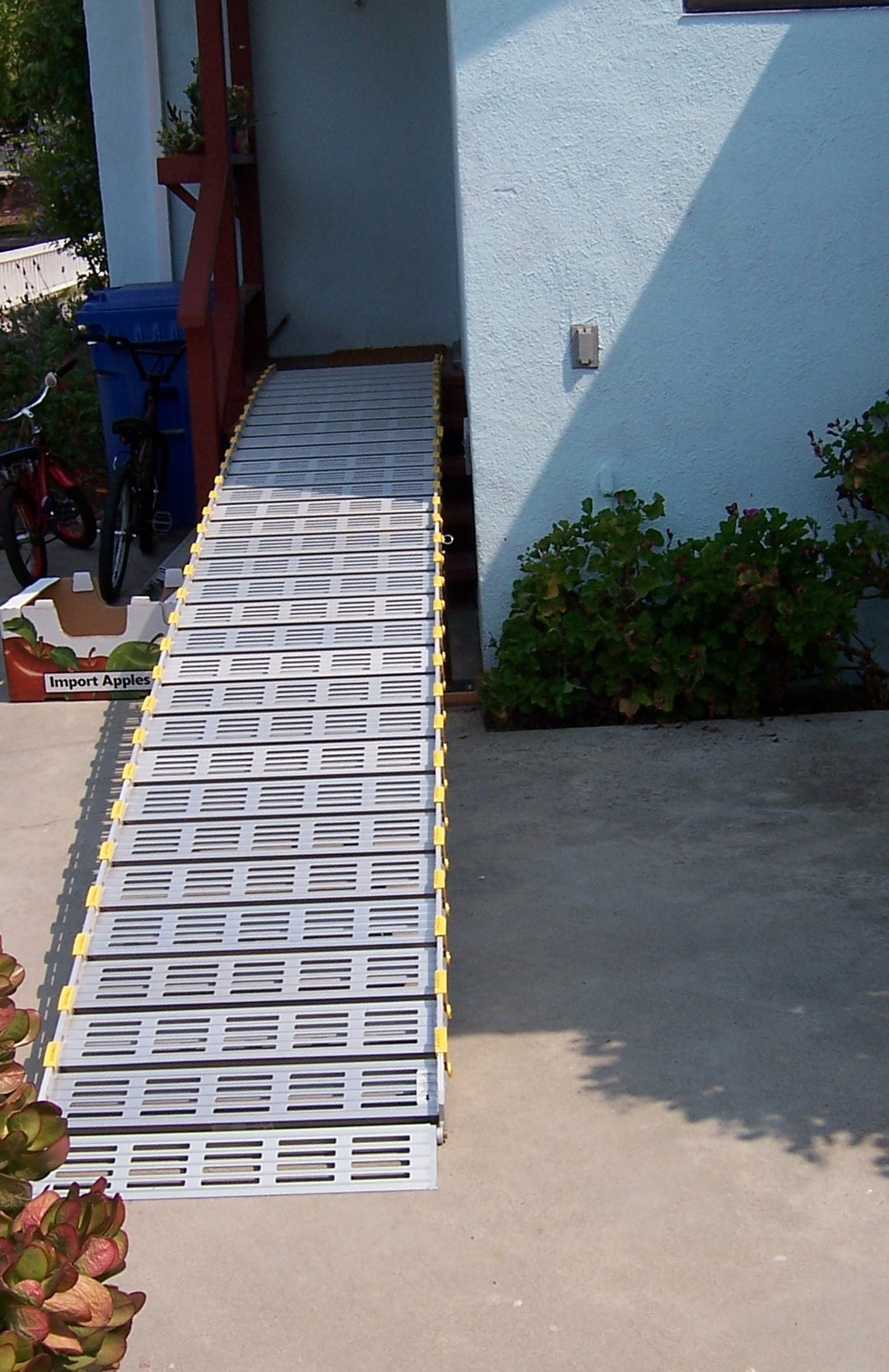 roll-a-ramp portable aluminum wheelchair ramp at reliable ramps coming out of a entrance with red wood stairs