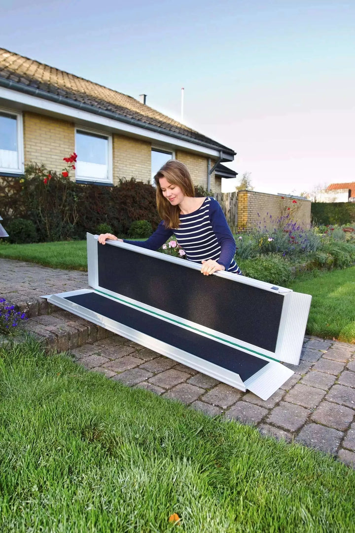 Guldmann - Stepless EasyFold Pro Portable Wheelchair Ramp being held by lady to show portability