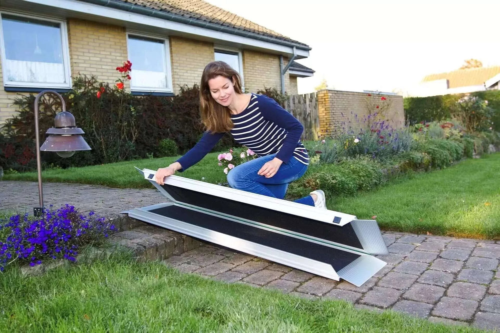 Guldmann - Stepless EasyFold Pro Portable Wheelchair Ramp being carried by a lady all folded up