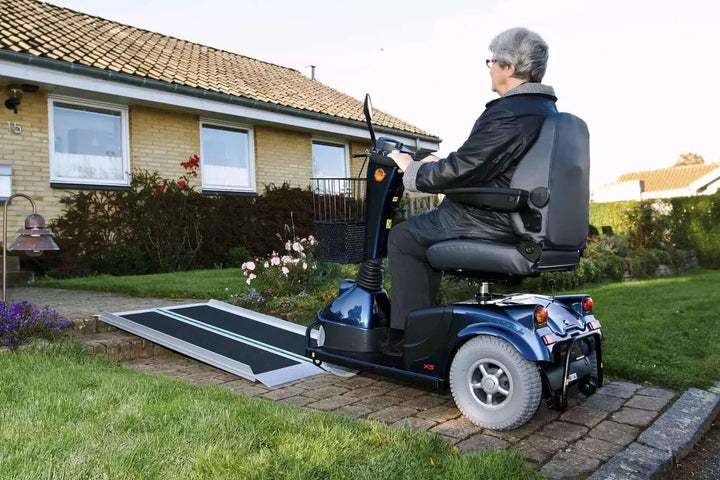 Guldmann - Stepless EasyFold Pro Portable Wheelchair Ramp being used by man in motorized scooter