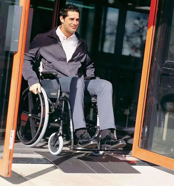 Guldmann - Stepless Doorstep Mobility Ramp being used by man outside in a wheelchair