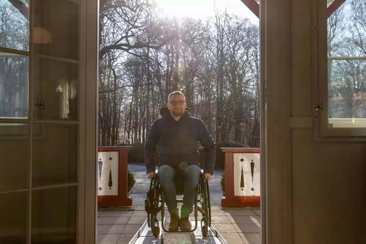 Guldmann - Stepless Telescopic Portable Wheelchair Ramp used by a patient coming out of a house