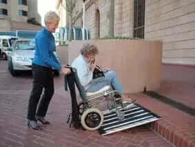DECPAC - Portable Fiberglass Folding Wheelchair Ramp - lady being pushed in a wheelchiar over a smaller threshold