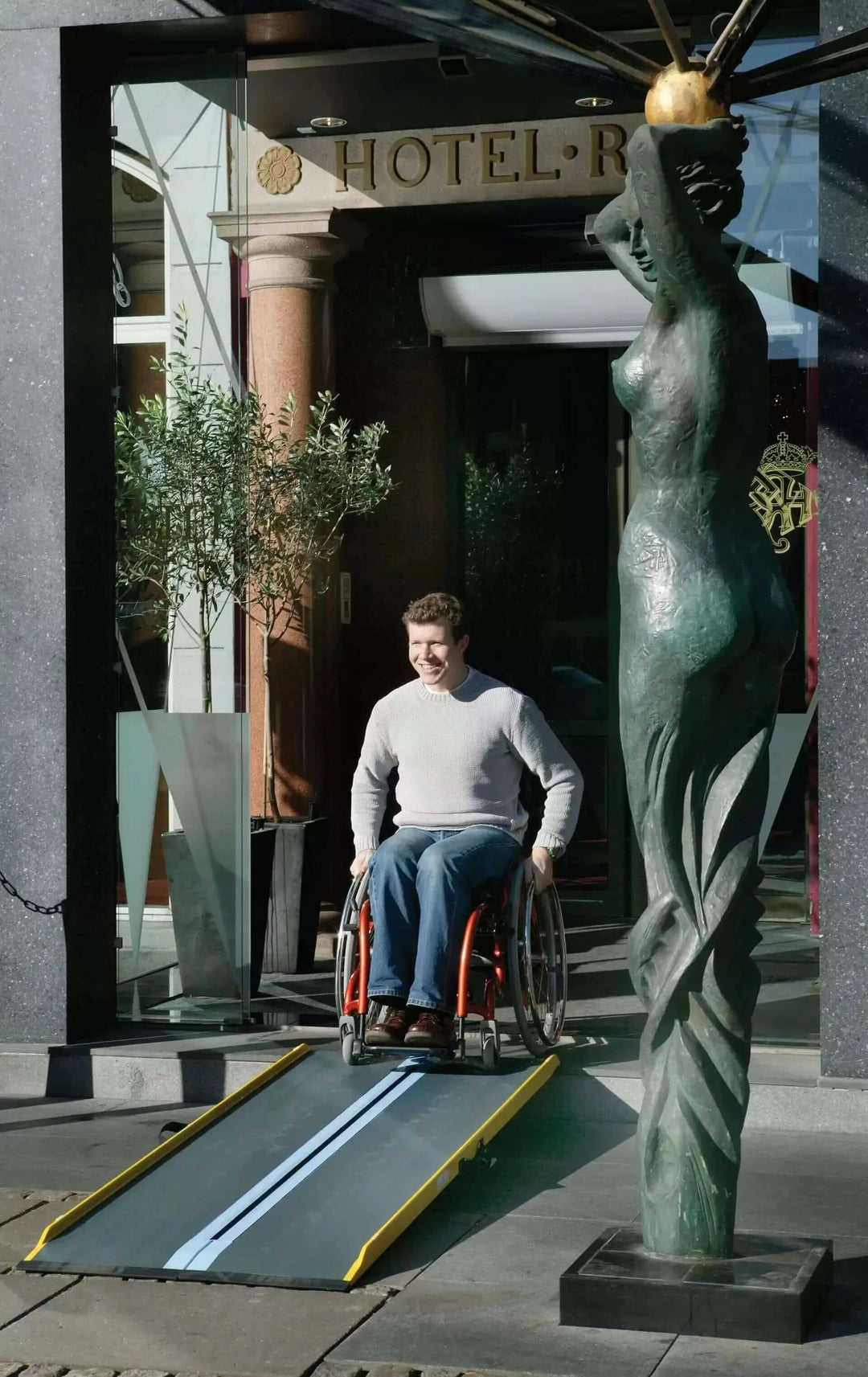 Guldmann - Stepless Single Folding Lite Wheelchair Ramp being used by a man going down it