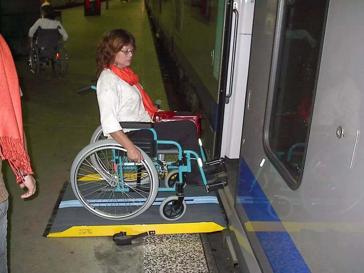 Guldmann - Stepless Multi Folding Lite Wheelchair Ramp being used by a patient going into a public transport