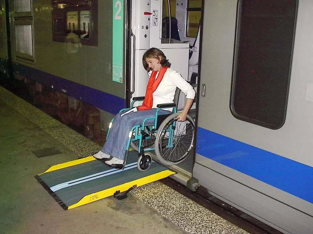 Guldmann - Stepless Multi Folding Lite Wheelchair Ramp being used by lady coming out of public transportation