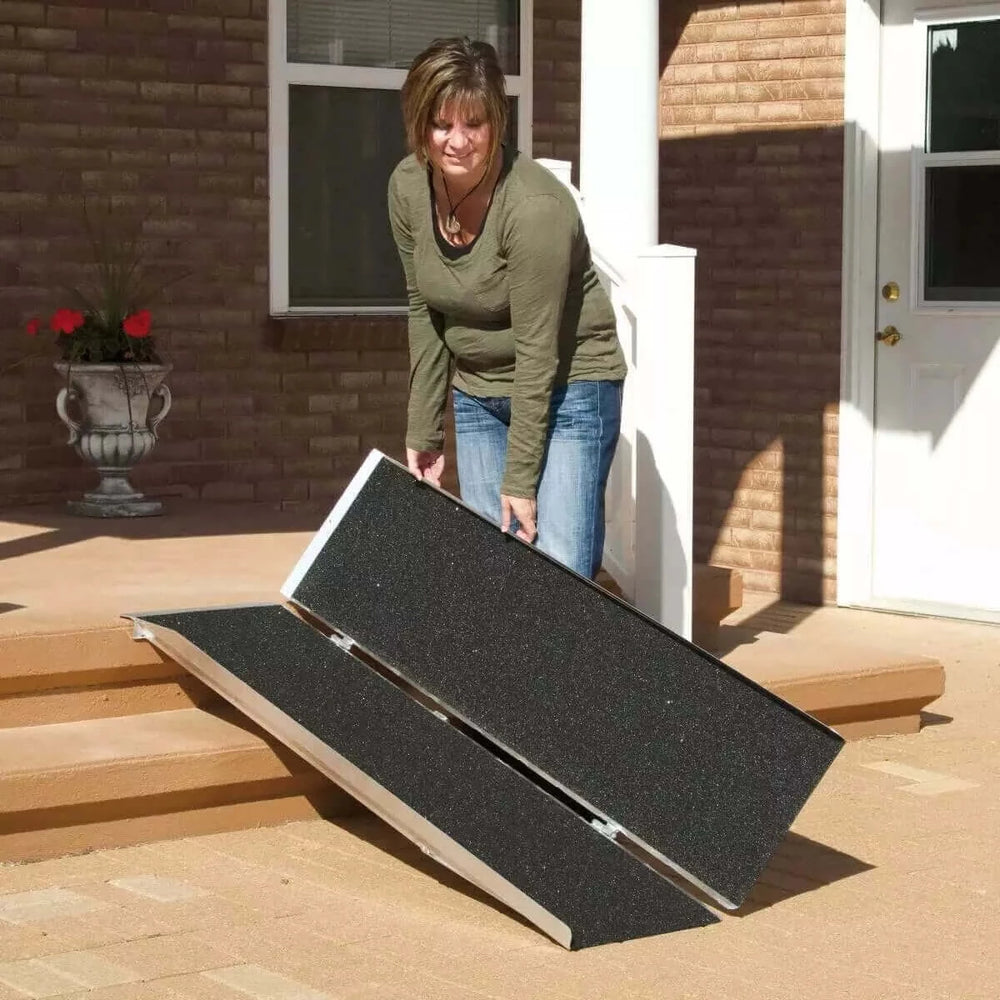 PVI - Aluminum Single Fold Threshold Ramp for Wheelchairs being folded up by lady in front of her home