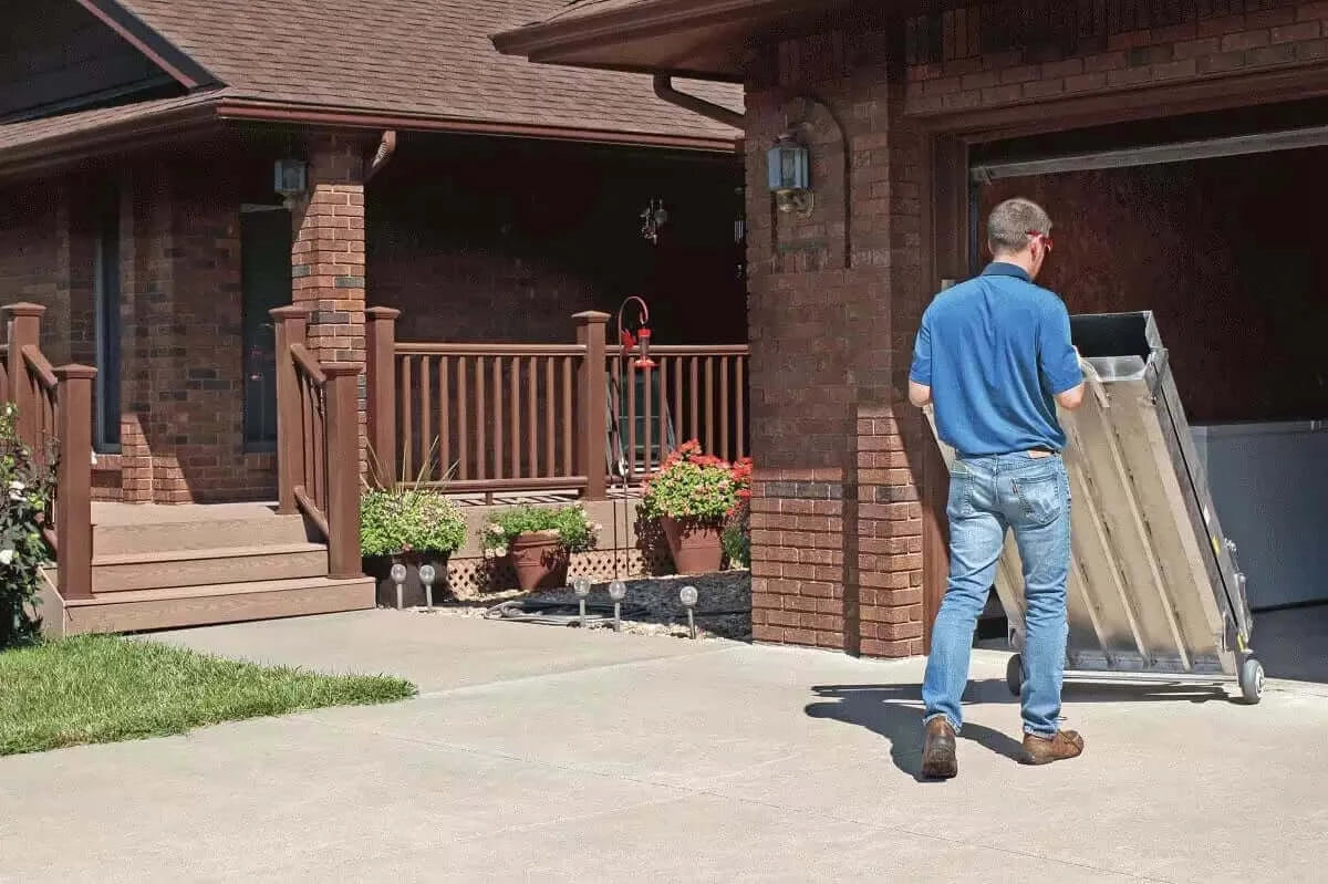 PVI Wheel-A-Bout Aluminum Portable Wheelchair Ramp being rolled away into the garage by a man