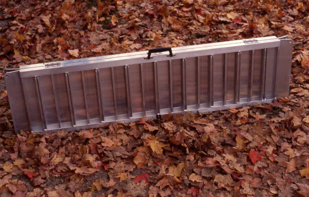AlumiLite Folding Wheelchair Curb Ramp - folded up on a bed of leaves