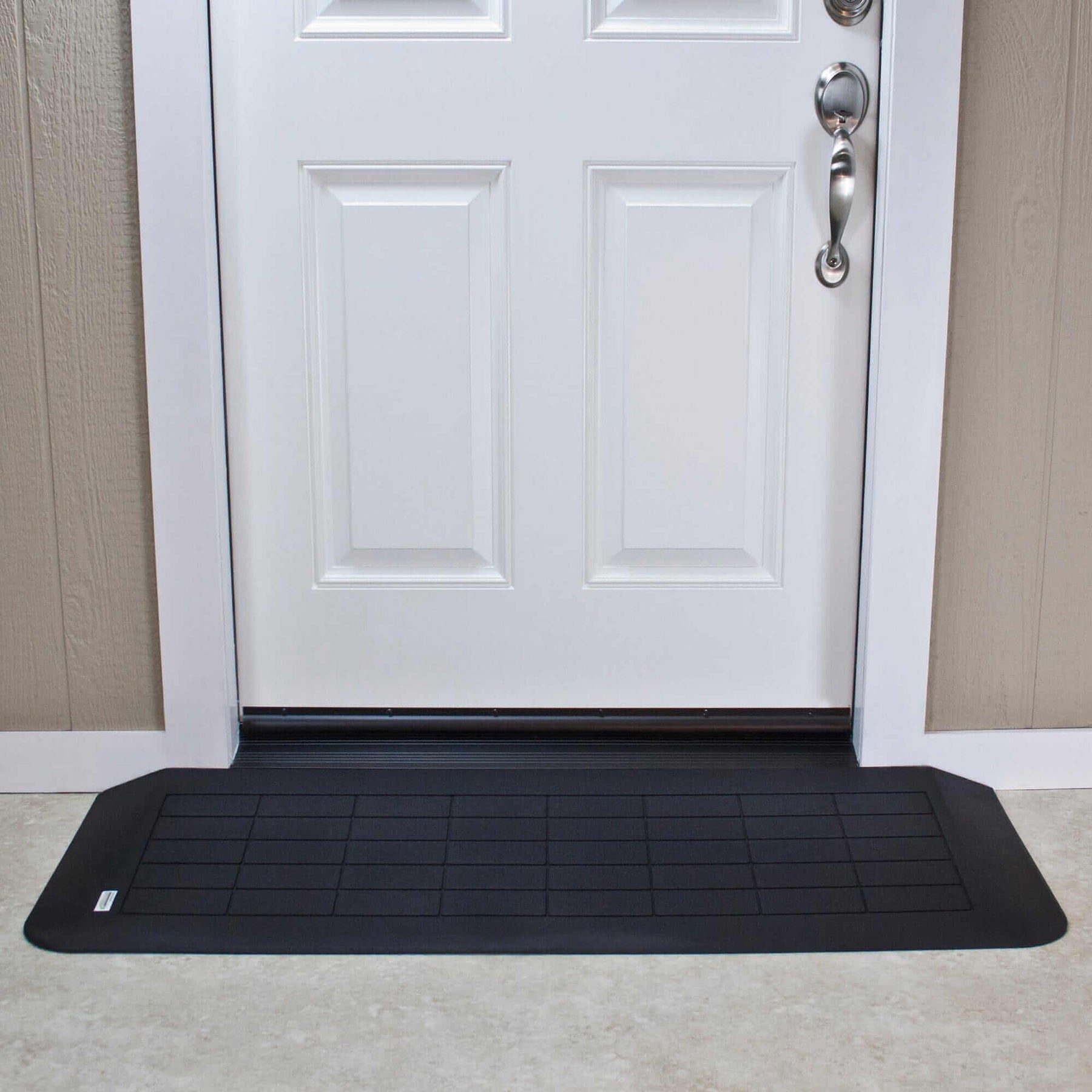 the AlumiRamp Rubber Threshold Ramp being used in front of a white door