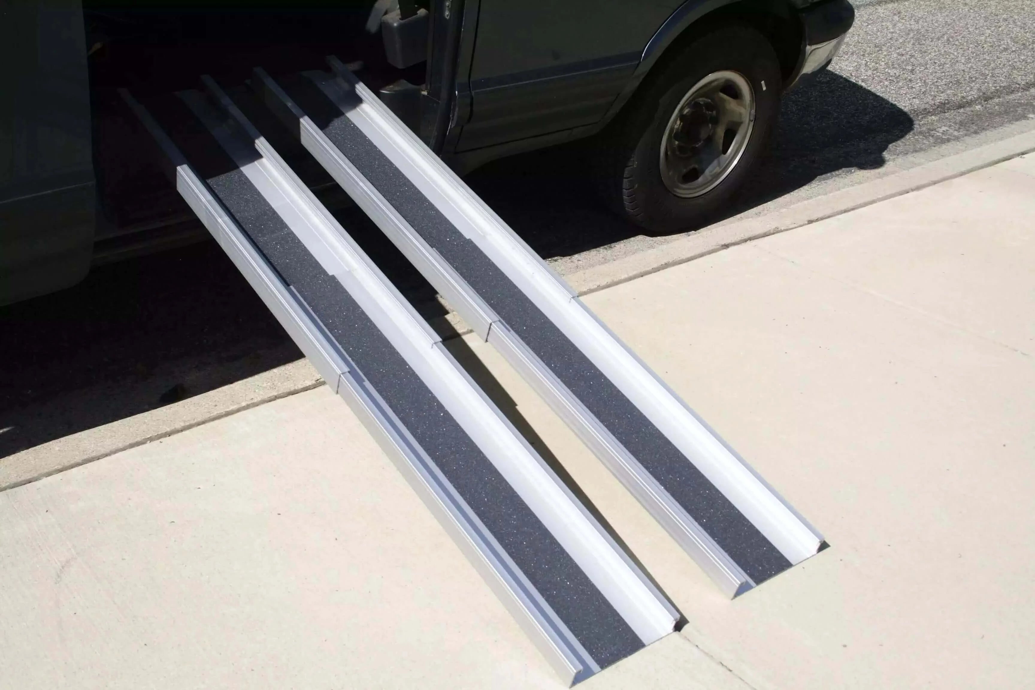 alumiramp telescopic ramps being used off a van onto a sidewalk